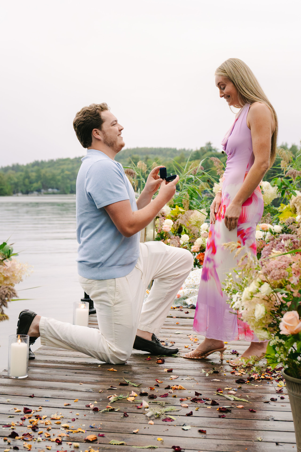 Aaron proposing to Leah on a dock surrounded by flowers